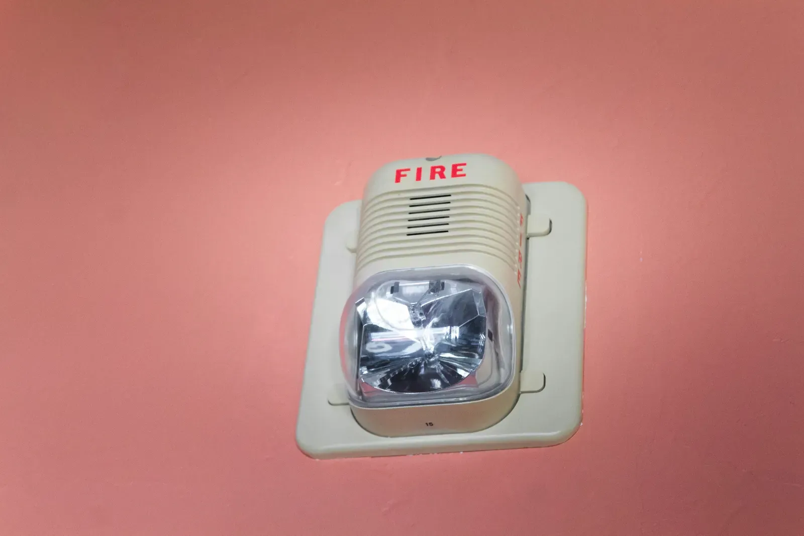 A wall-mounted fire alarm strobe